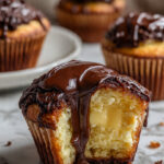 Boston cream pie cupcake with creamy custard center and glossy chocolate glaze dripping over a soft vanilla crumb.